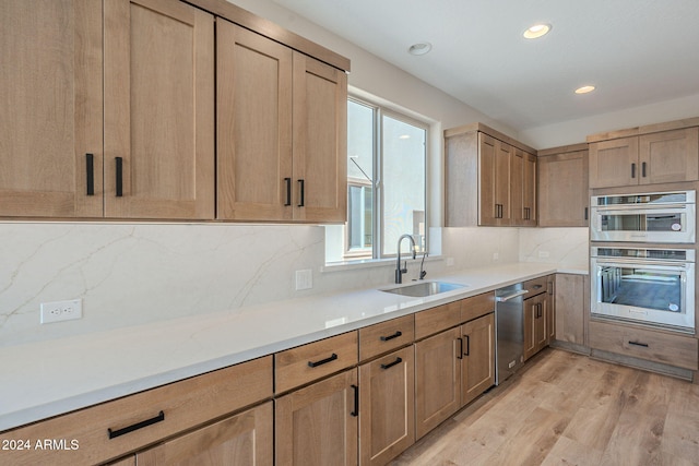 kitchen with decorative backsplash, light wood-type flooring, sink, and appliances with stainless steel finishes