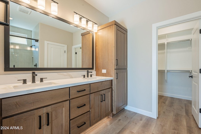 bathroom featuring hardwood / wood-style flooring, vanity, and an enclosed shower