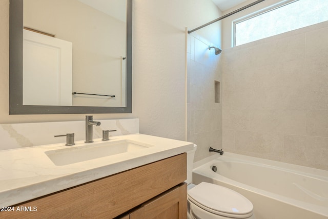 full bathroom featuring tiled shower / bath combo, toilet, and vanity