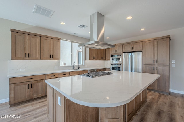 kitchen featuring a center island, sink, light wood-type flooring, island exhaust hood, and stainless steel appliances