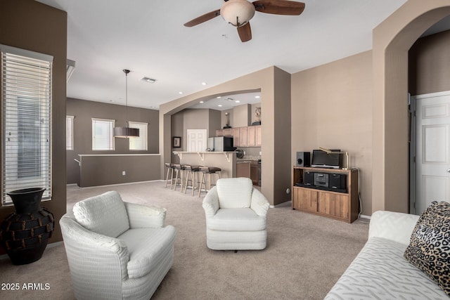 carpeted living room with ceiling fan