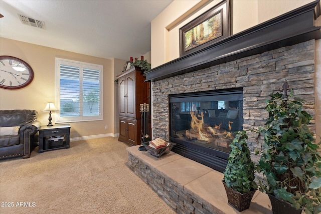 living room featuring visible vents, baseboards, light colored carpet, and a fireplace