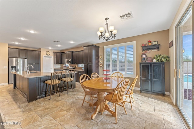 dining space featuring visible vents, baseboards, an inviting chandelier, and stone tile flooring