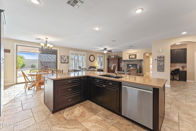 kitchen featuring visible vents, a sink, stone tile floors, open floor plan, and dishwasher