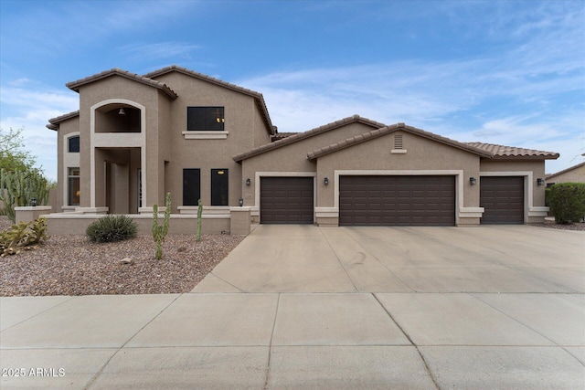 view of front facade featuring a garage, a tile roof, driveway, and stucco siding