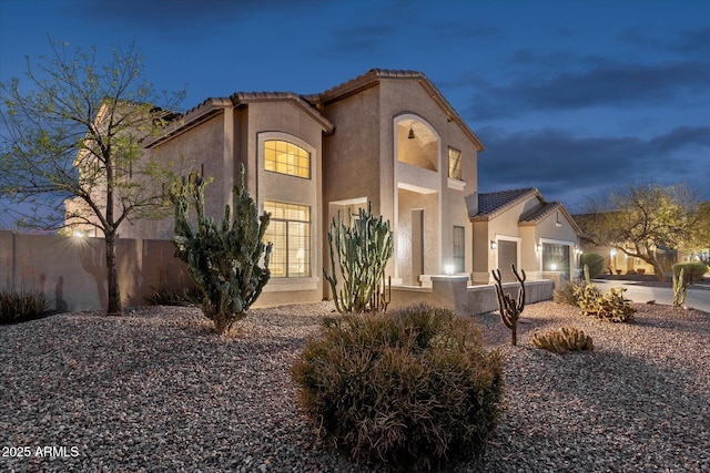 mediterranean / spanish-style home featuring stucco siding, a garage, concrete driveway, and a tile roof