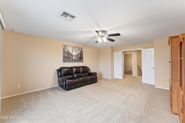 living area featuring visible vents, ceiling fan, baseboards, carpet floors, and an upstairs landing