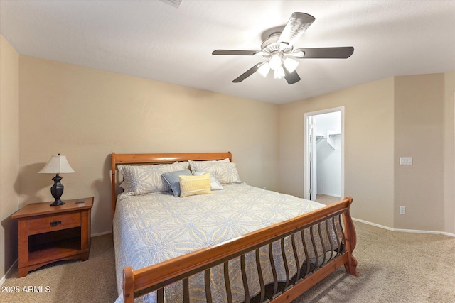 bedroom featuring a walk in closet, a ceiling fan, a closet, carpet floors, and baseboards