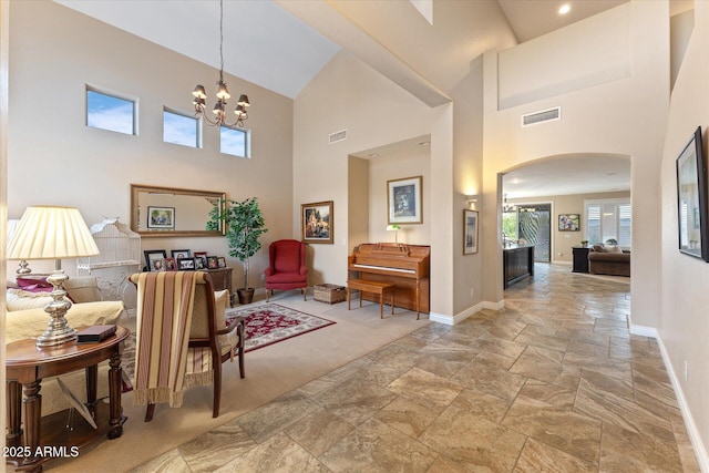 interior space with arched walkways, visible vents, a notable chandelier, and baseboards