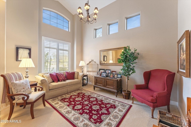 living area with plenty of natural light, high vaulted ceiling, an inviting chandelier, and carpet floors