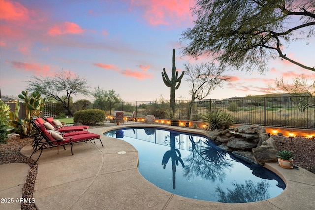 pool at dusk with a patio area