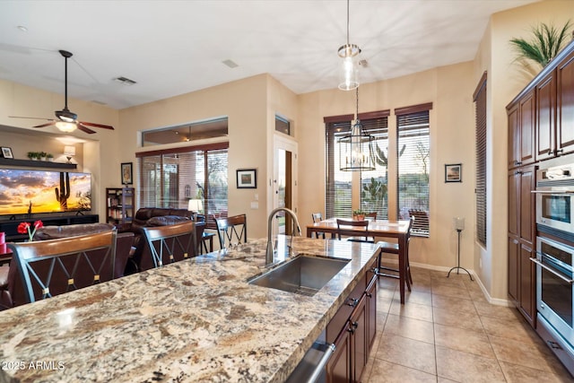 kitchen featuring sink, a wealth of natural light, a breakfast bar area, and hanging light fixtures