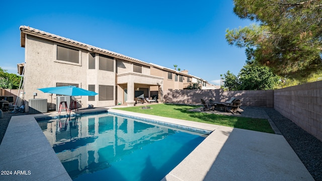 view of pool with central AC unit, a patio area, and a lawn