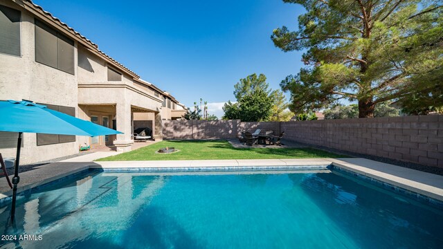 view of pool featuring a lawn and a patio