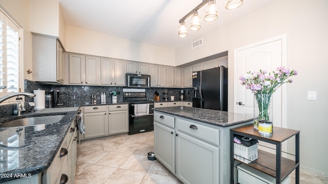 kitchen featuring black appliances, sink, dark stone countertops, tasteful backsplash, and a kitchen island