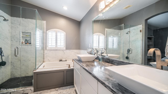 bathroom featuring plus walk in shower, vanity, and vaulted ceiling