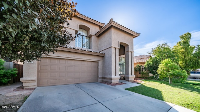 mediterranean / spanish house featuring a front yard and a garage