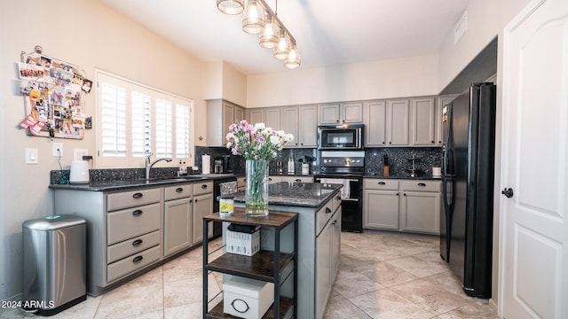 kitchen featuring gray cabinetry, backsplash, pendant lighting, a kitchen island, and black appliances