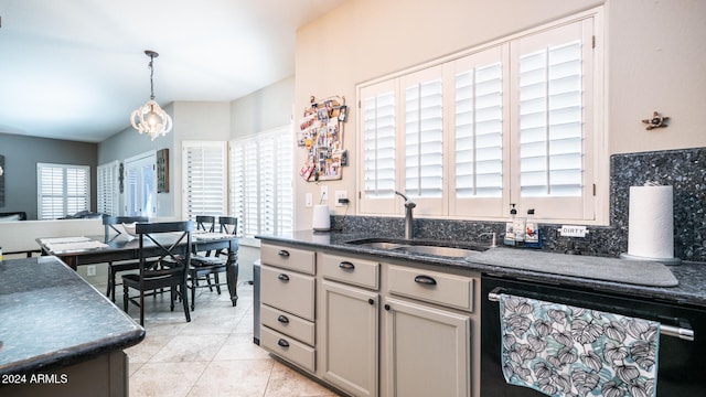 kitchen featuring hanging light fixtures, black dishwasher, plenty of natural light, and sink