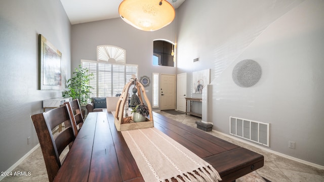 dining area featuring high vaulted ceiling