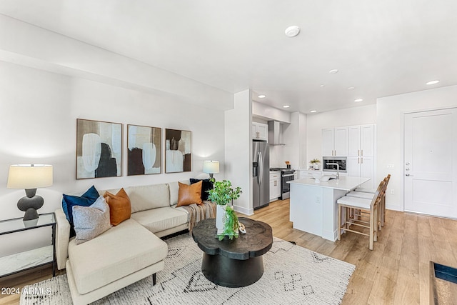 living room with light hardwood / wood-style floors and sink