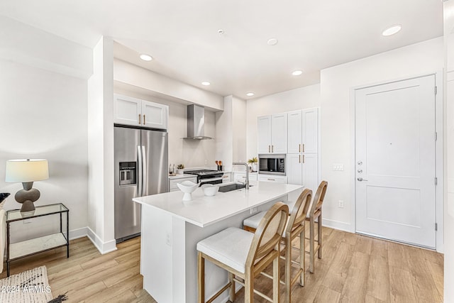 3131 N Central Ave Unit 6017, Phoenix, AZ 85012 - kitchen featuring black appliances, wall chimney range hood, light wood-style flooring, a kitchen bar, and light countertops