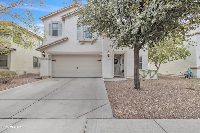 view of front of house with a garage, concrete driveway, a tile roof, and stucco siding