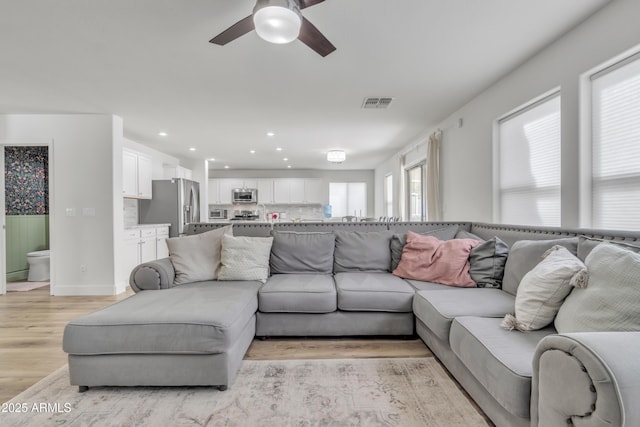 living area featuring light wood-style floors, recessed lighting, visible vents, and a ceiling fan