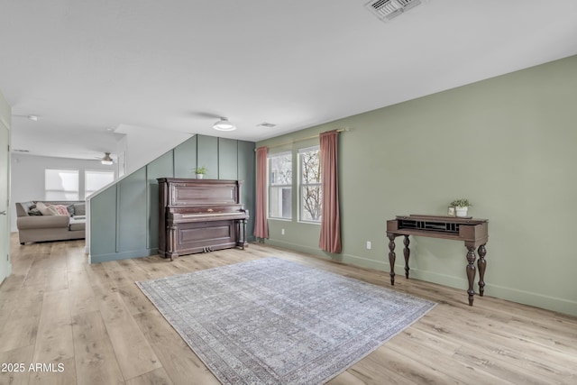 interior space featuring baseboards, visible vents, and wood finished floors