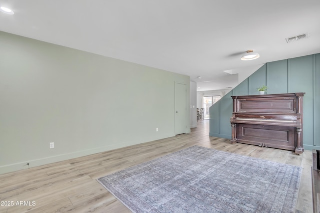 living room featuring baseboards, visible vents, and light wood-style floors