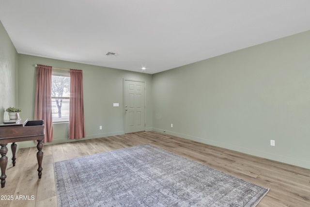 interior space featuring baseboards, visible vents, and light wood finished floors