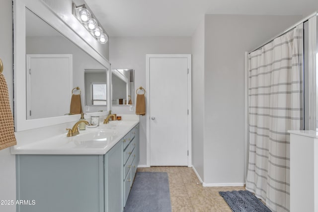 full bathroom featuring double vanity, baseboards, a sink, and a shower with shower curtain