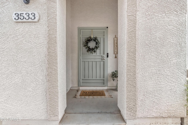 entrance to property featuring stucco siding