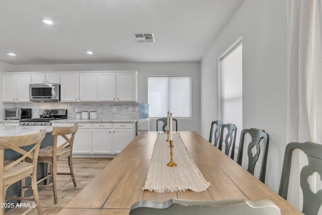 dining area featuring light wood-style floors, visible vents, and recessed lighting