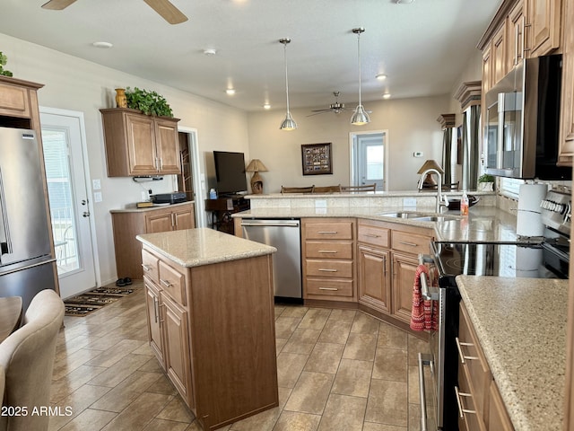 kitchen with sink, decorative light fixtures, a kitchen island, kitchen peninsula, and stainless steel appliances