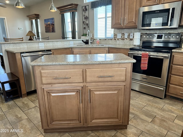 kitchen with sink, a center island, stainless steel appliances, backsplash, and decorative light fixtures