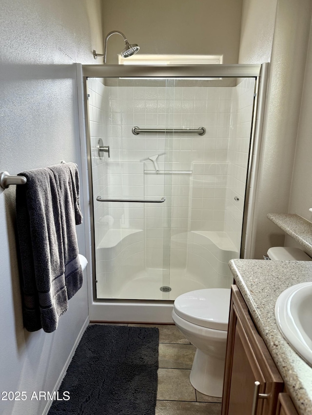 bathroom with vanity, toilet, and a shower with shower door