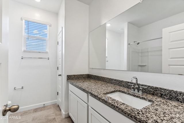 bathroom featuring walk in shower and vanity