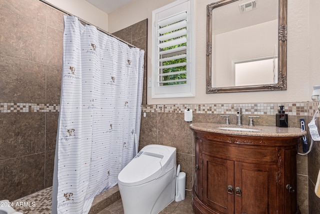 bathroom featuring tile patterned flooring, a shower with curtain, vanity, toilet, and tile walls