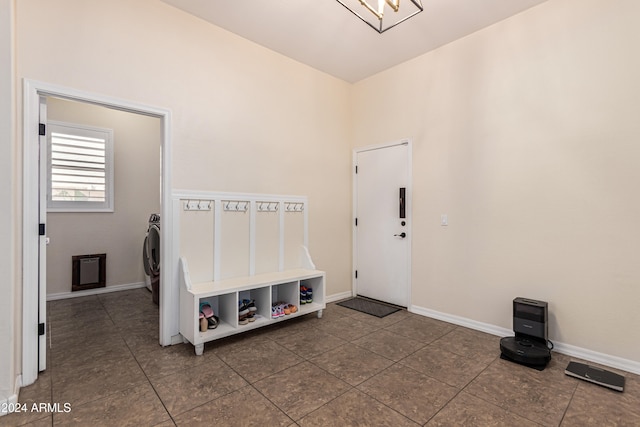 interior space with washer / dryer, tile patterned floors, and a notable chandelier