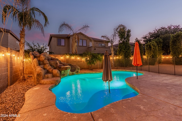 pool at dusk featuring a patio area