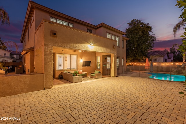 rear view of house featuring a fenced in pool, an outdoor hangout area, and a patio