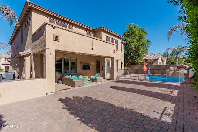 back of house featuring a patio area, a fenced in pool, and an outdoor hangout area