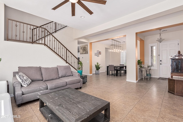 living room with ceiling fan with notable chandelier and light tile patterned floors