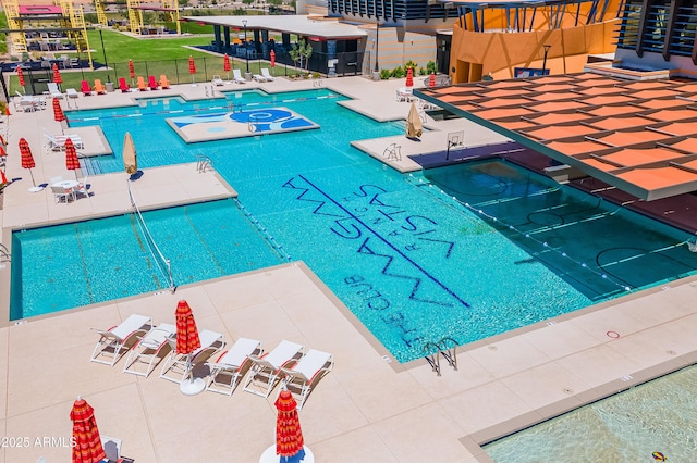 community pool with a patio area and fence