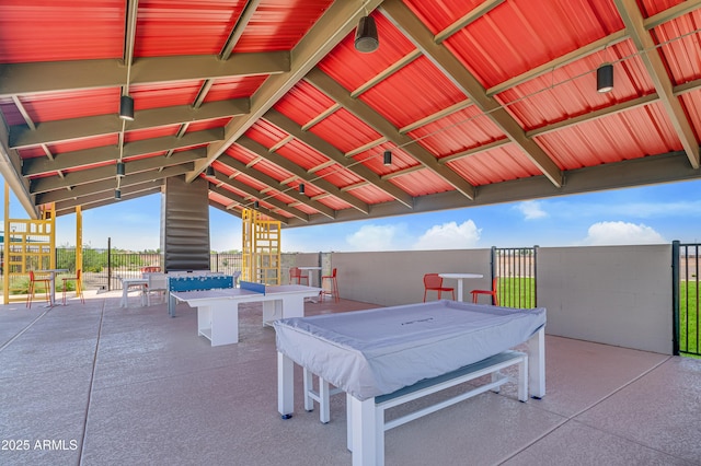 exterior space featuring vaulted ceiling and concrete block wall