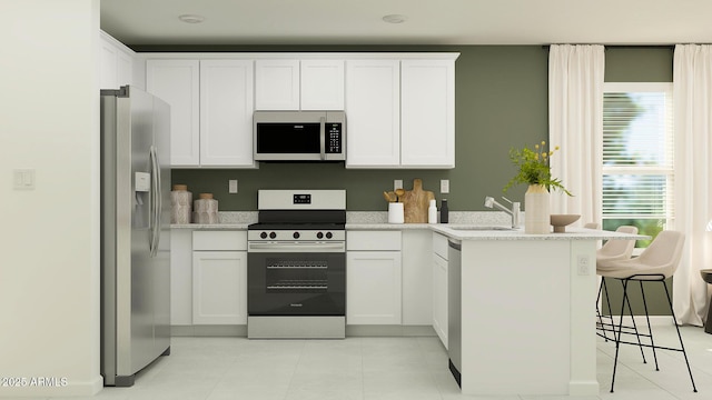 kitchen with stainless steel appliances, white cabinetry, and a peninsula