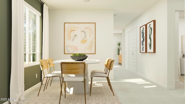 dining space featuring light tile patterned floors and baseboards