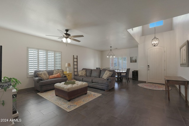 living room featuring a wealth of natural light, dark hardwood / wood-style floors, and ceiling fan with notable chandelier