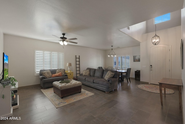 living room with a textured ceiling and ceiling fan with notable chandelier